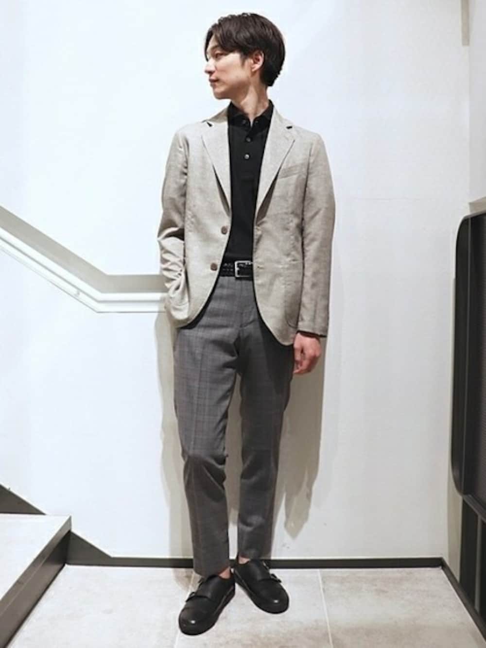 ベージュ系のテーラードジャケット、ブラック系のポロシャツ、グレー系のその他パンツを着用したメンズの夏コーディネートの1枚目の写真