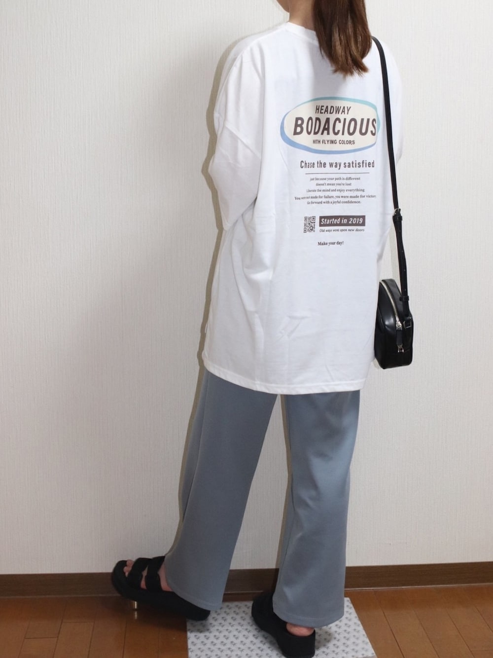 ホワイト系のTシャツ/カットソー、ベージュ系のパンツ、ブラック系のショルダーバッグを着用したレディースの夏コーディネートの1枚目の写真
