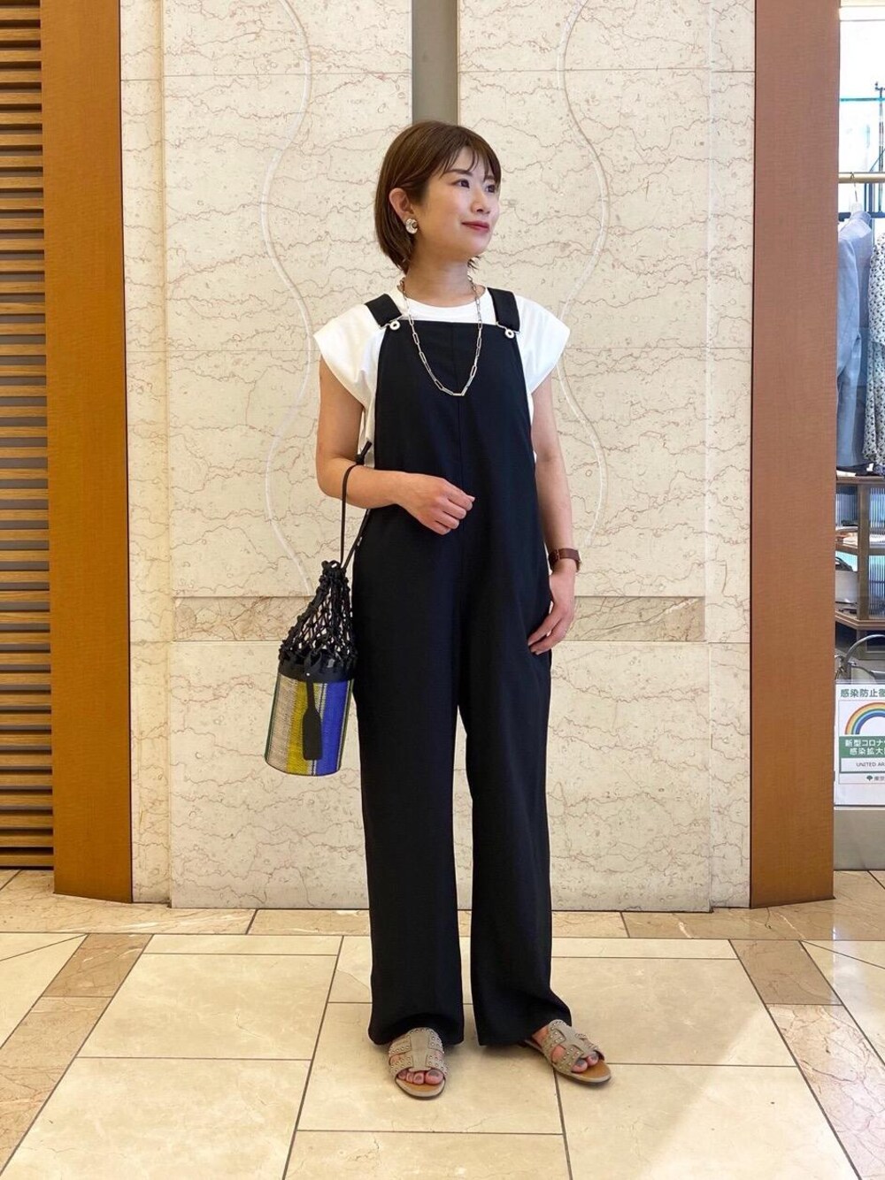 ブラック系のサロペット/オーバーオール、ベージュ系のサンダル、ホワイト系のTシャツ/カットソーを着用したレディースの春コーディネートの1枚目の写真