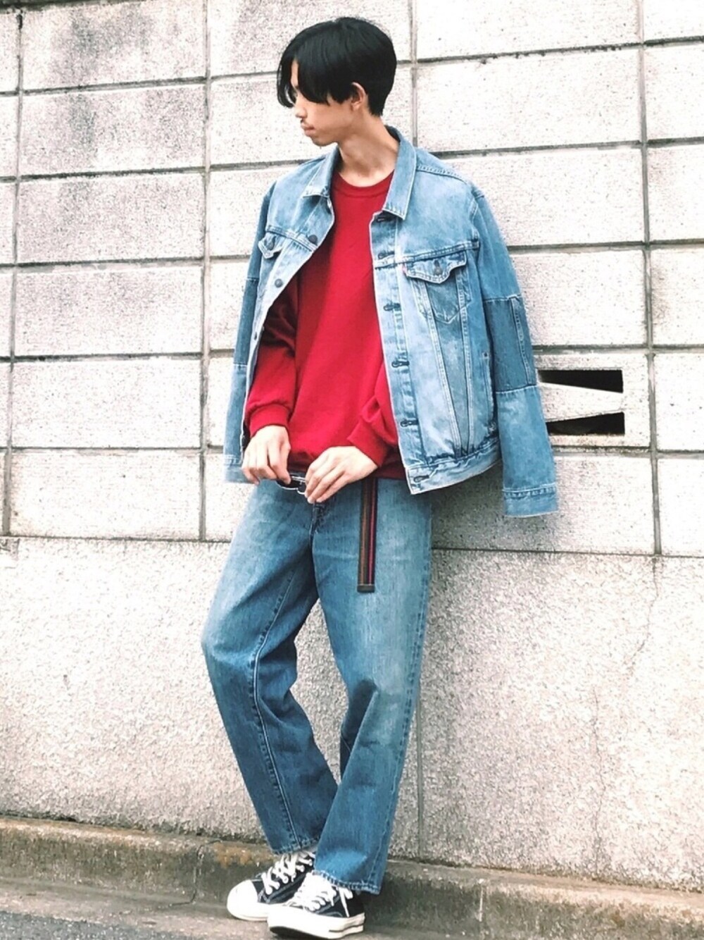 ブルー系のデニムジャケット、ブルー系のデニムパンツ、ブラック系のスニーカーを着用したメンズの秋コーディネートの1枚目の写真