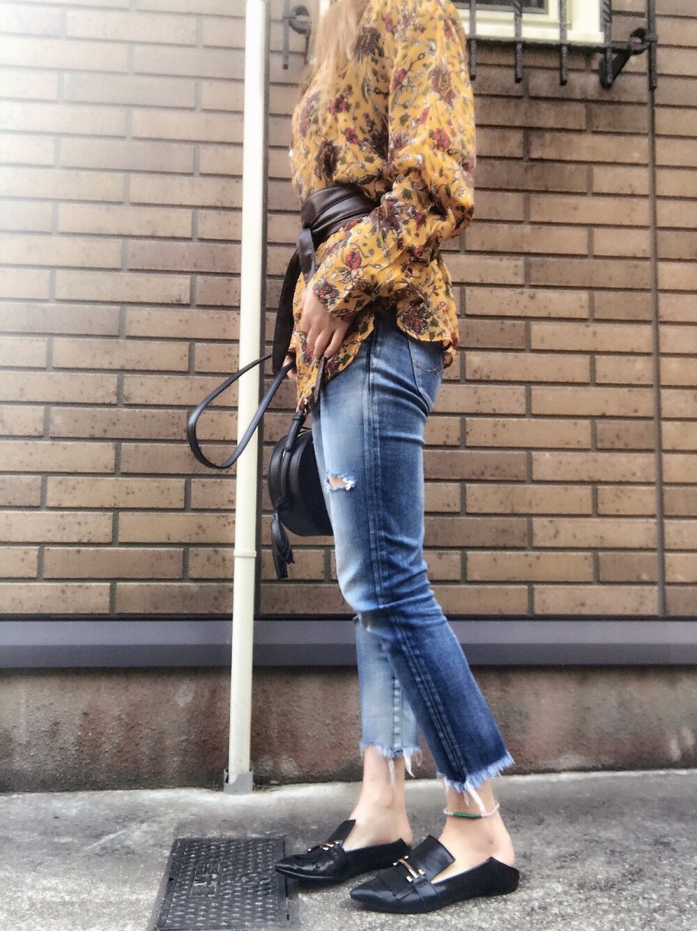 イエロー系のシャツ/ブラウス、ブルー系のデニムパンツ、ブラック系のモカシン/デッキシューズを着用したレディースの春コーディネートの1枚目の写真