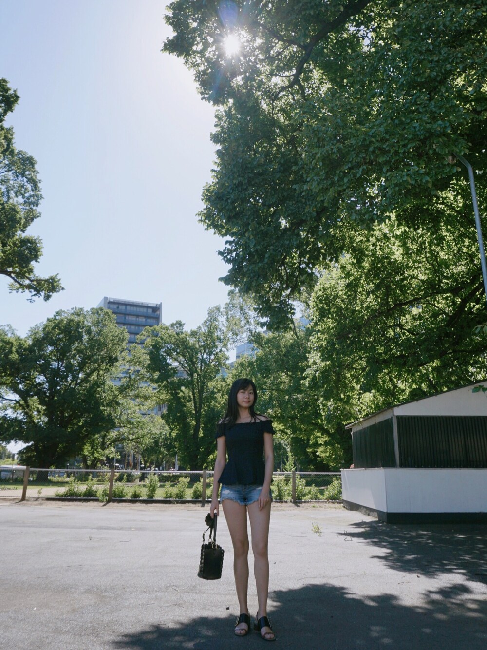 ブルー系のチューブトップ、ブルー系のデニムパンツ、ブラック系のショルダーバッグを着用したレディースの冬コーディネートの1枚目の写真