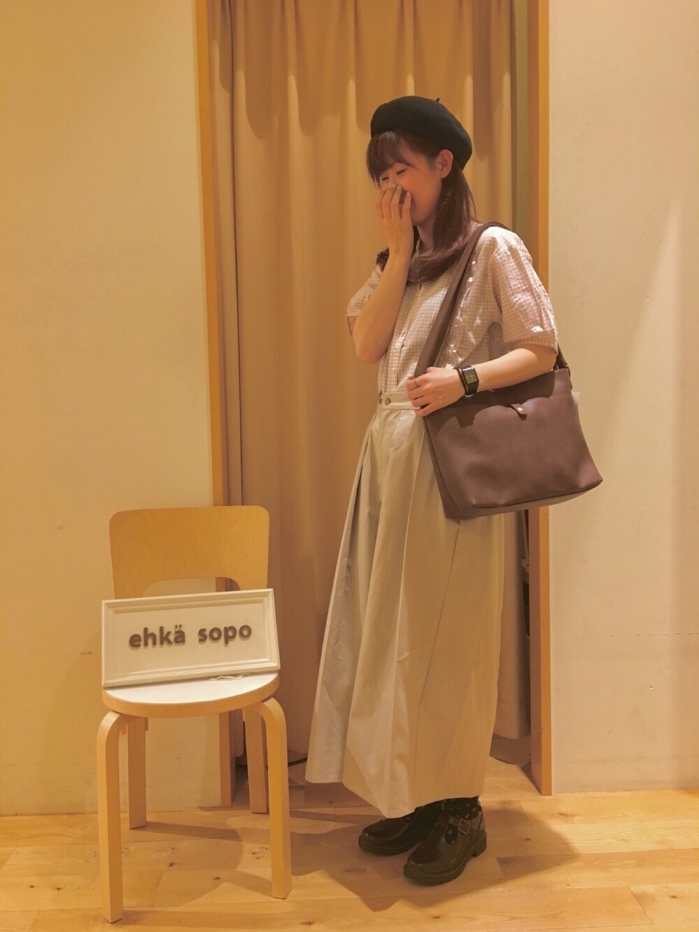 ベージュ系のパンツ、ブラウン系のバッグ、ホワイト系のシャツ/ブラウスを着用したレディースの春コーディネートの1枚目の写真