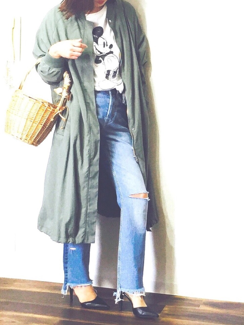 グリーン系のミリタリージャケット、ベージュ系のかごバッグ、ブラック系のパンプスを着用したレディースの春コーディネートの1枚目の写真