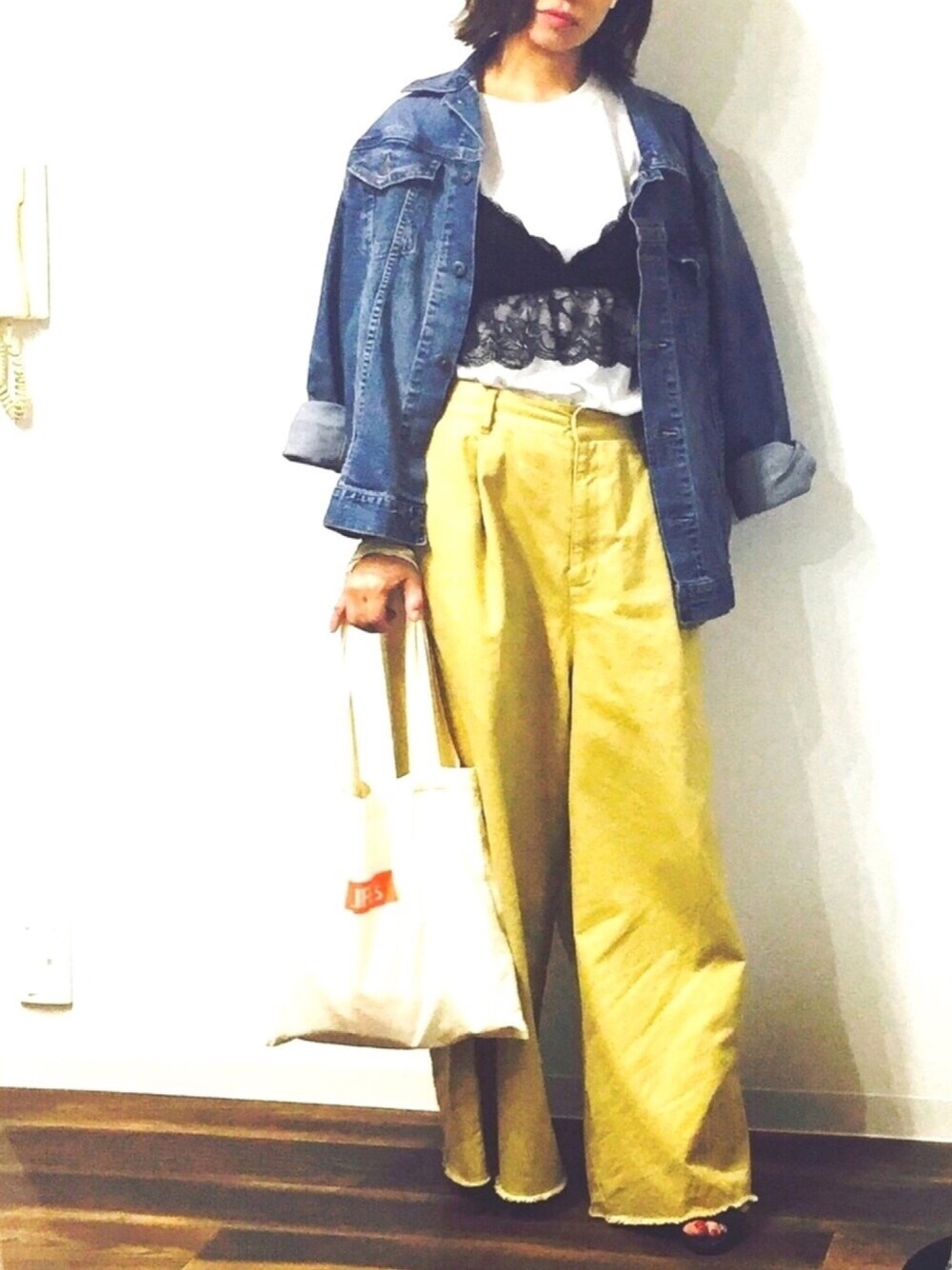 ブルー系のデニムジャケット、ブラック系のキャミソール、ベージュ系のその他パンツを着用したレディースの春コーディネートの1枚目の写真