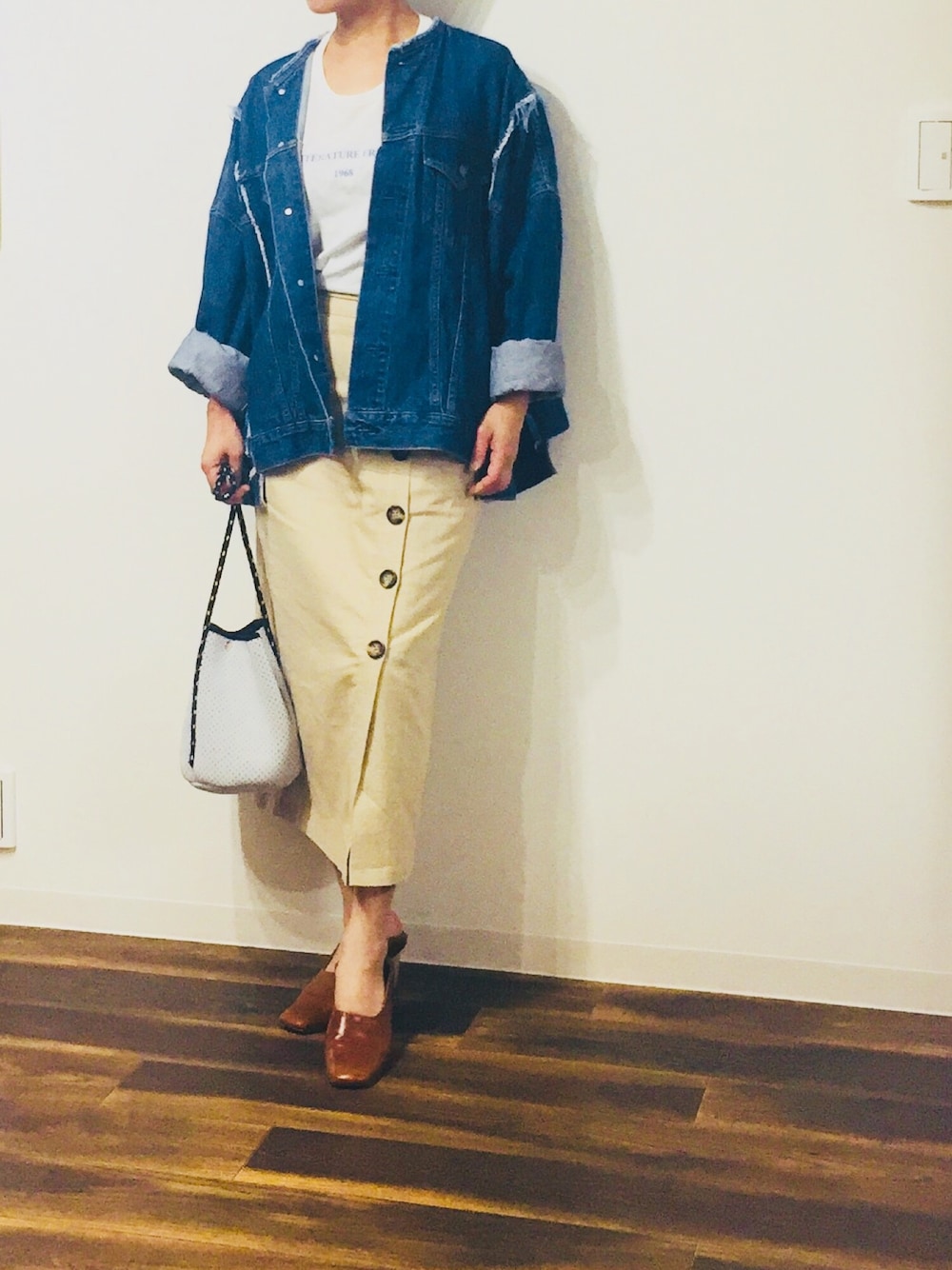 ブルー系のデニムジャケット、ホワイト系のTシャツ/カットソー、ベージュ系のスカートを着用したレディースの春コーディネートの1枚目の写真