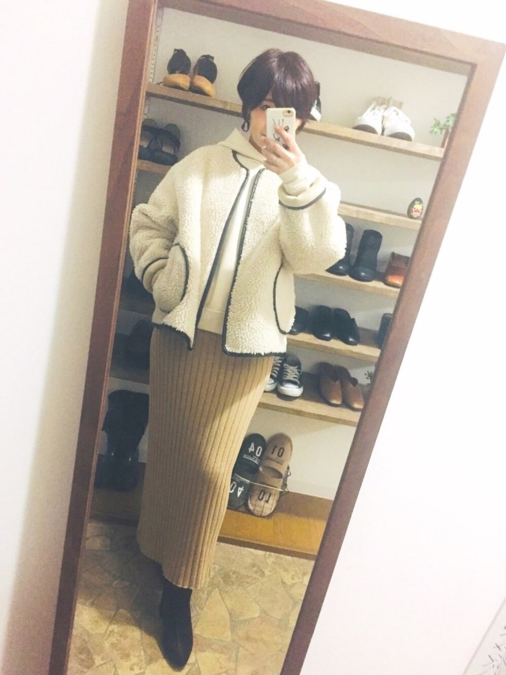 ホワイト系のブルゾン、ベージュ系のスカート、ブラウン系のブーツを着用したレディースの冬コーディネートの1枚目の写真