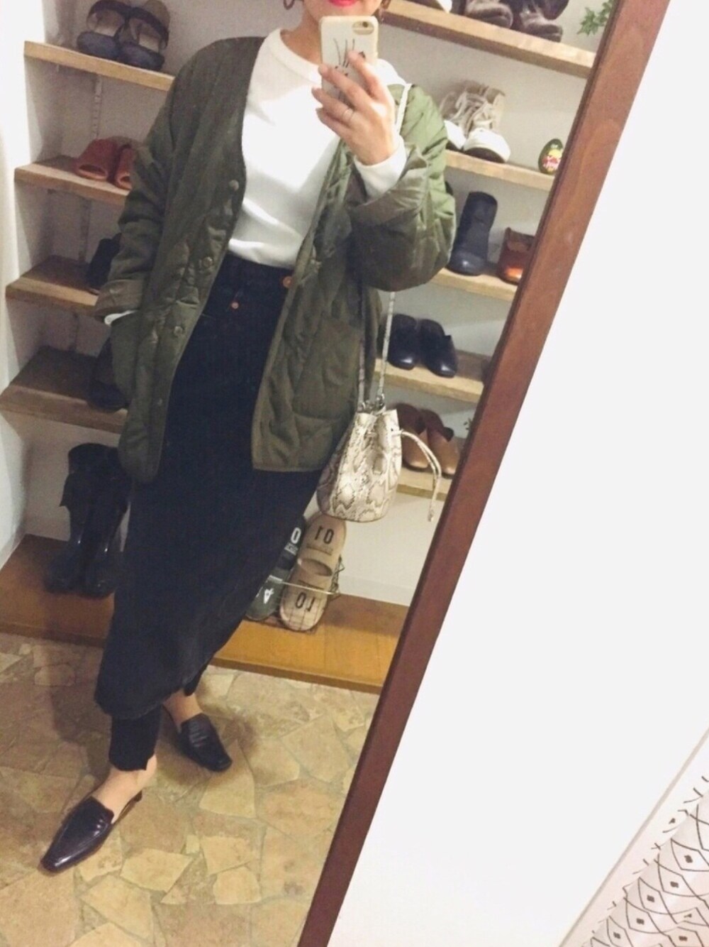 ホワイト系のTシャツ/カットソー、ブラック系のデニムスカート、ブラック系のパンプスを着用したレディースの冬コーディネートの1枚目の写真