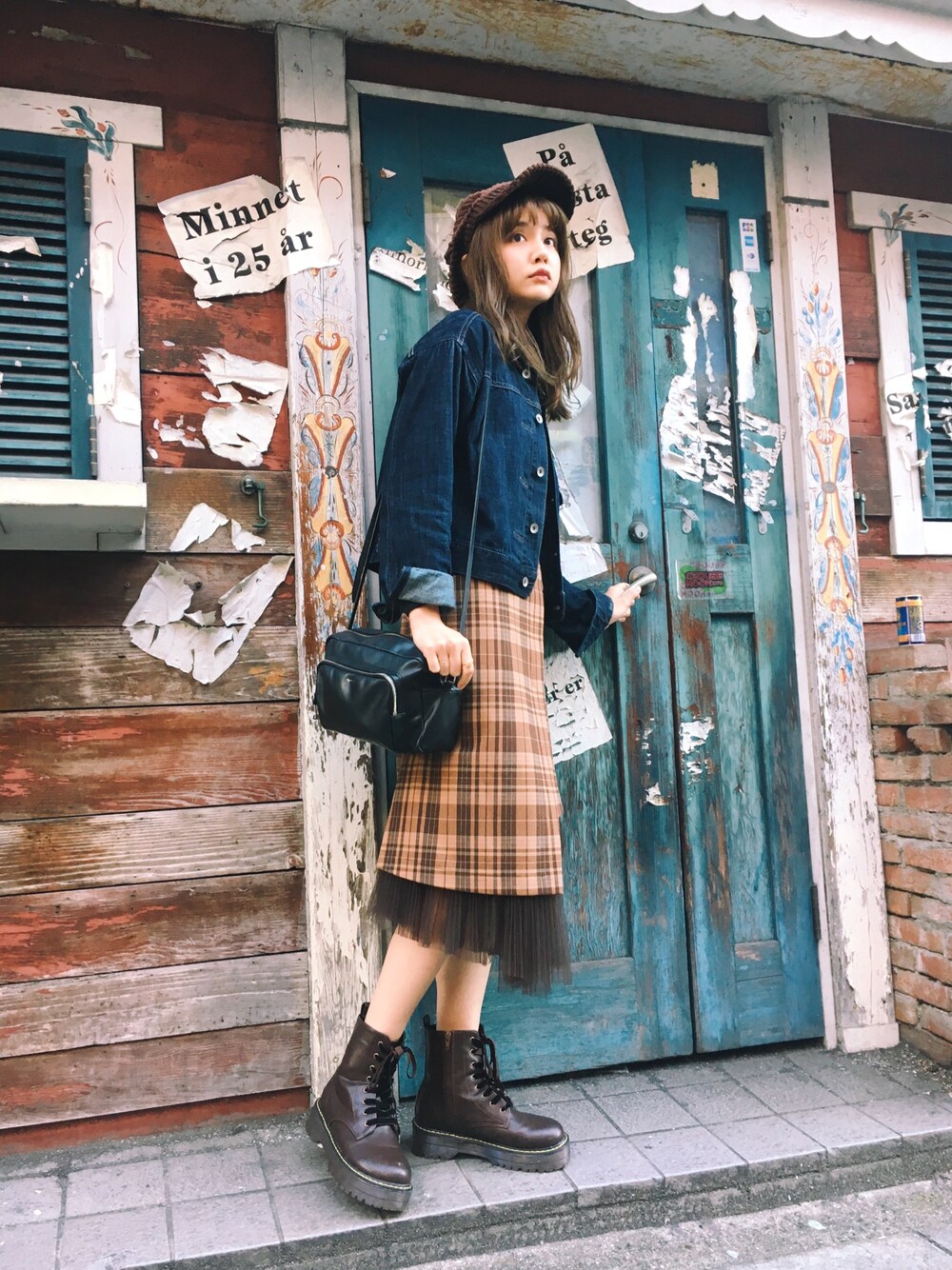 ブルー系のデニムジャケット、ベージュ系のスカート、ブラウン系のブーティを着用したレディースの秋コーディネートの1枚目の写真