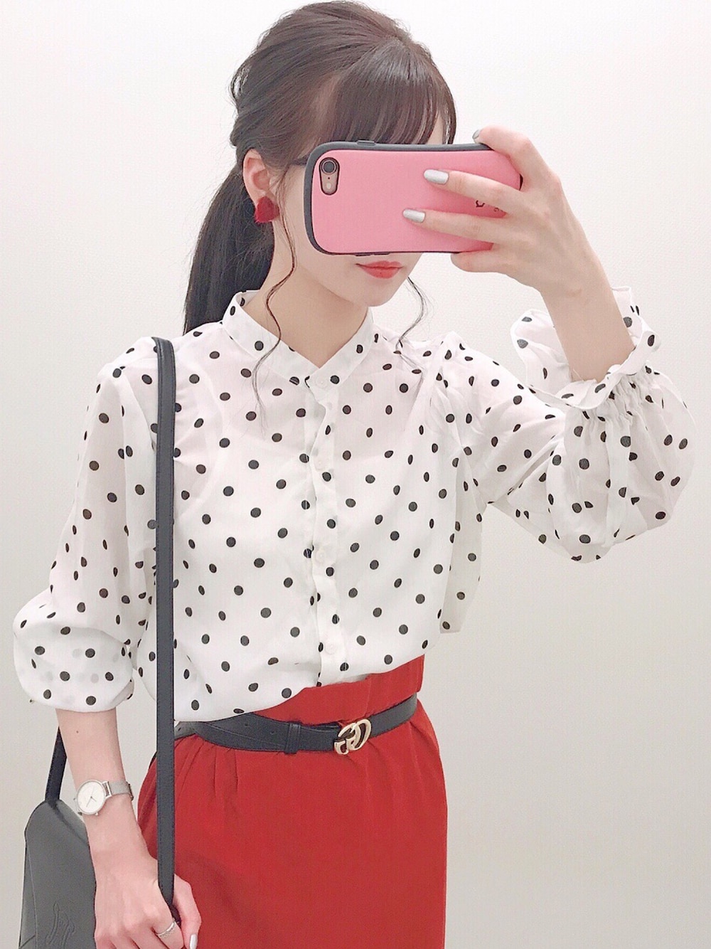 レッド系のスカートを着用したレディースの秋コーディネートの1枚目の写真