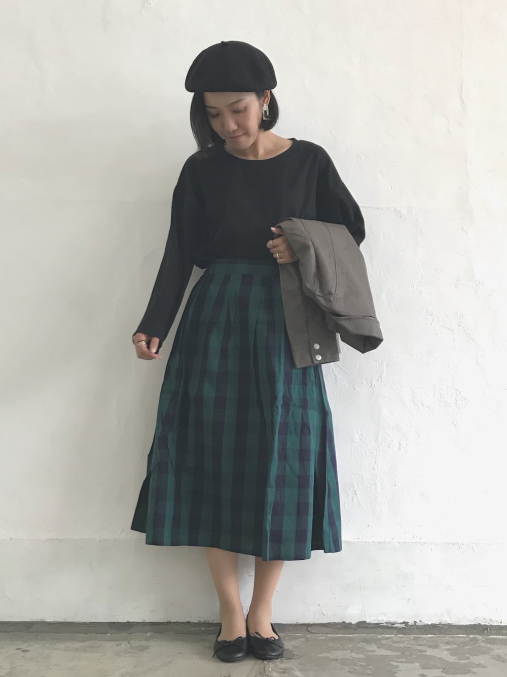 グリーン系のスカート、ブラック系のTシャツ/カットソー、グレー系のライダースジャケットを着用したレディースの秋コーディネートの1枚目の写真