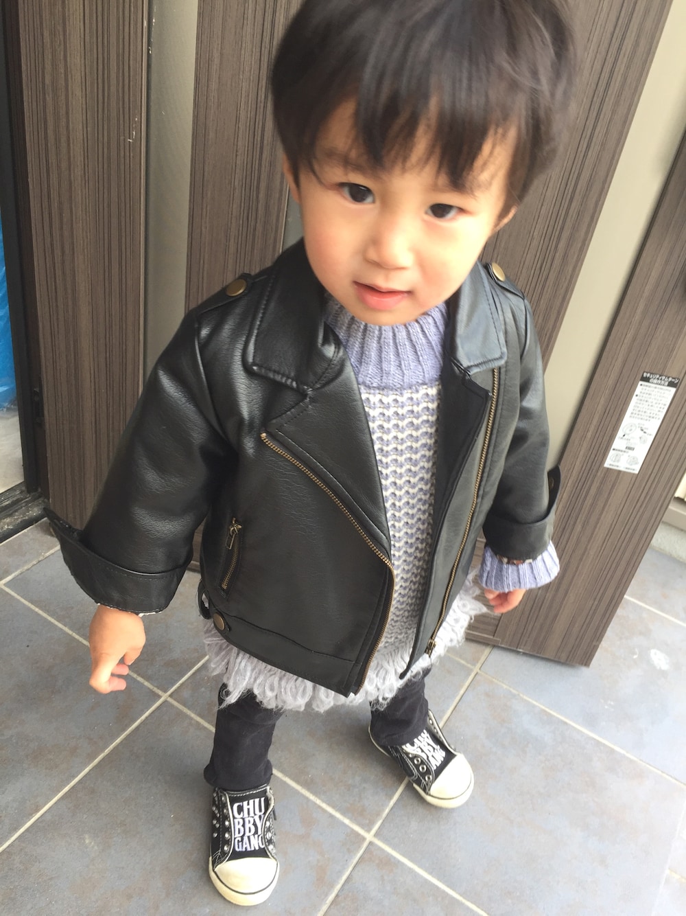 グレー系のニット/セーター、ブラック系のデニムパンツ、ブラック系のスニーカーを着用したキッズの春コーディネートの1枚目の写真