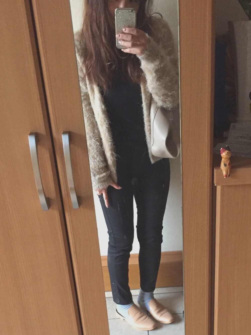 ブラック系のニット/セーター、ベージュ系のカーディガン/ボレロ、ブラック系のその他パンツを着用したレディースの春コーディネートの1枚目の写真