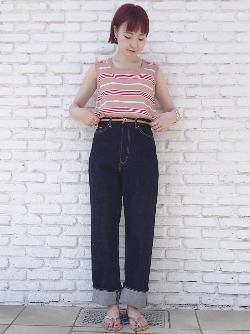 ピンク系のニット/セーター、ブルー系のデニムパンツを着用したレディースの夏コーディネートの1枚目の写真