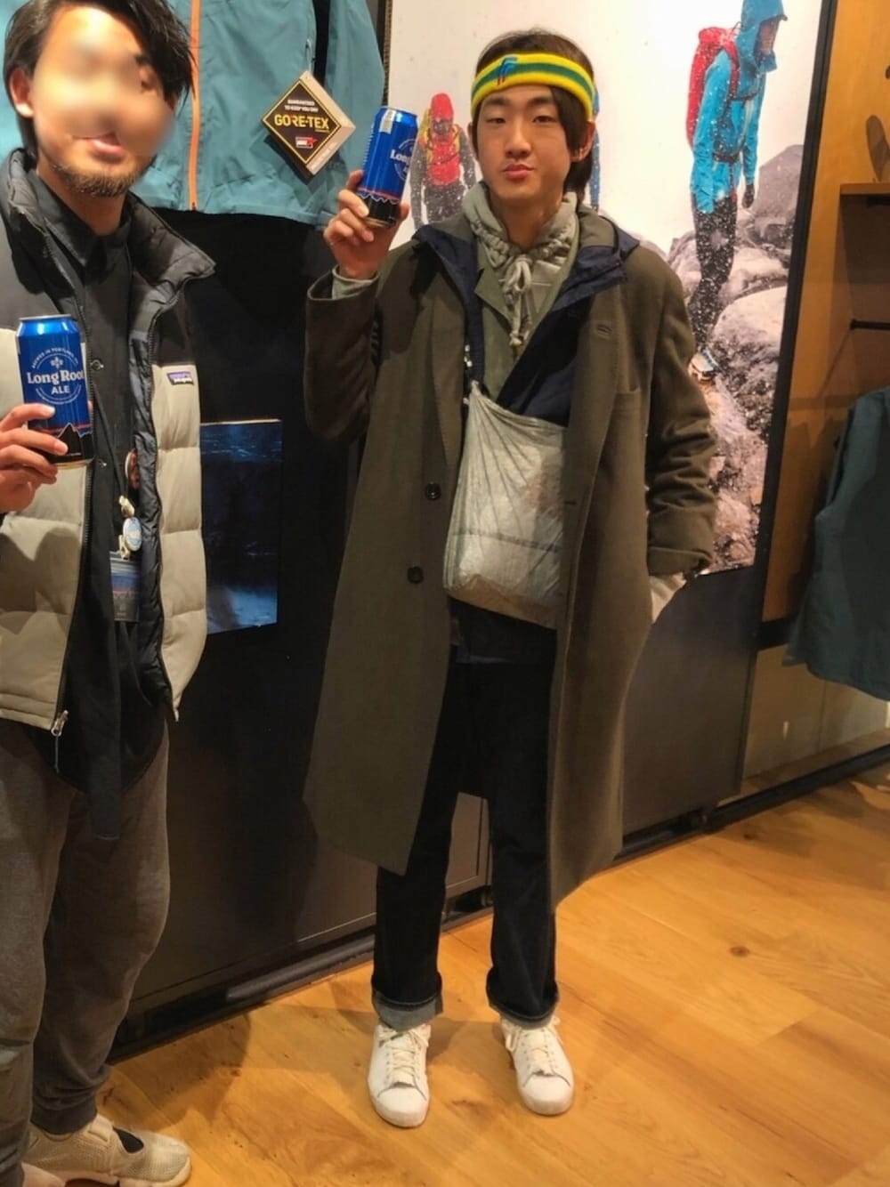 グリーン系のチェスターコート、グレー系のショルダーバッグ、ブルー系のデニムパンツを着用したメンズの春コーディネートの1枚目の写真