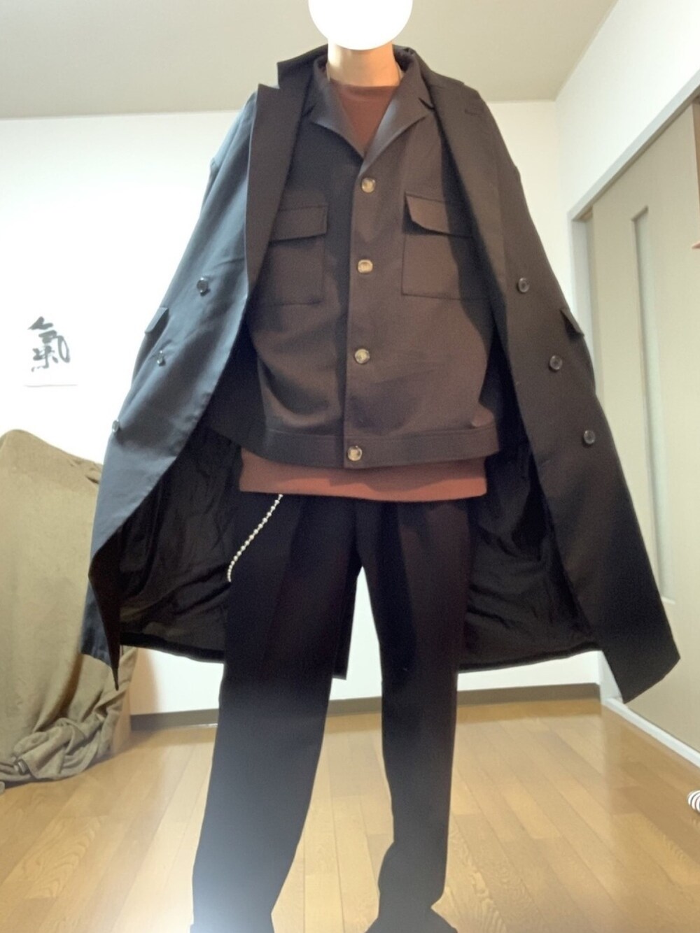 ブラック系のブルゾン、ブラック系のチェスターコート、ブラウン系のスウェットを着用したメンズの冬コーディネートの1枚目の写真