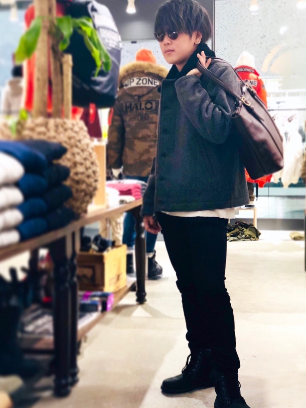 グレー系のミリタリージャケット、ブラウン系のバッグ、ホワイト系のTシャツ/カットソーを着用したメンズの秋コーディネートの1枚目の写真