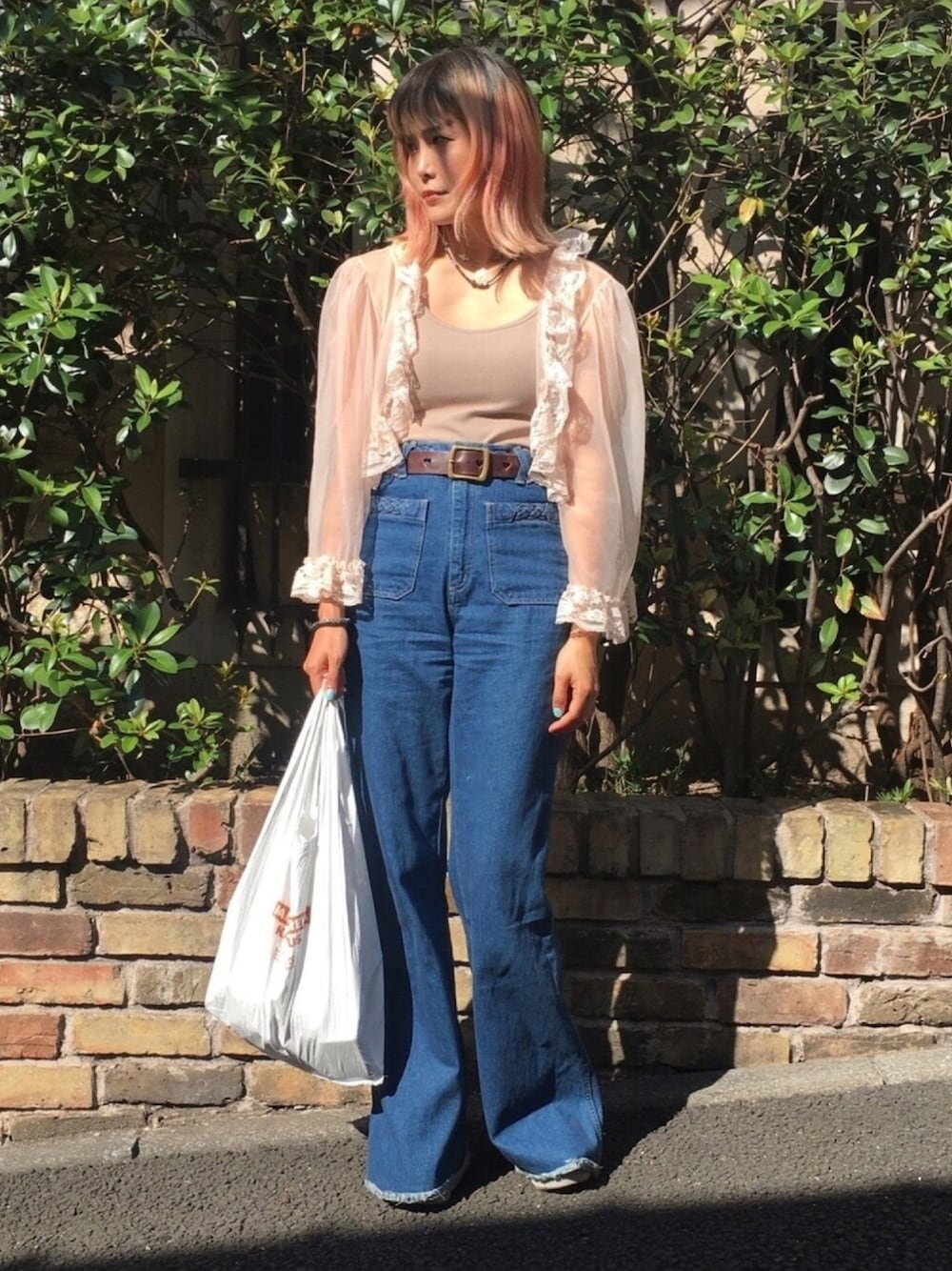 ブルー系のデニムパンツ、ホワイト系のバッグ、ピンク系のカーディガン/ボレロを着用したレディースの夏コーディネートの1枚目の写真