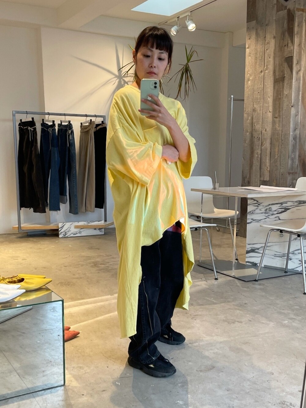 イエロー系のTシャツ/カットソー、ブラック系のデニムパンツ、ブラック系のスニーカーを着用したレディースの秋コーディネートの1枚目の写真