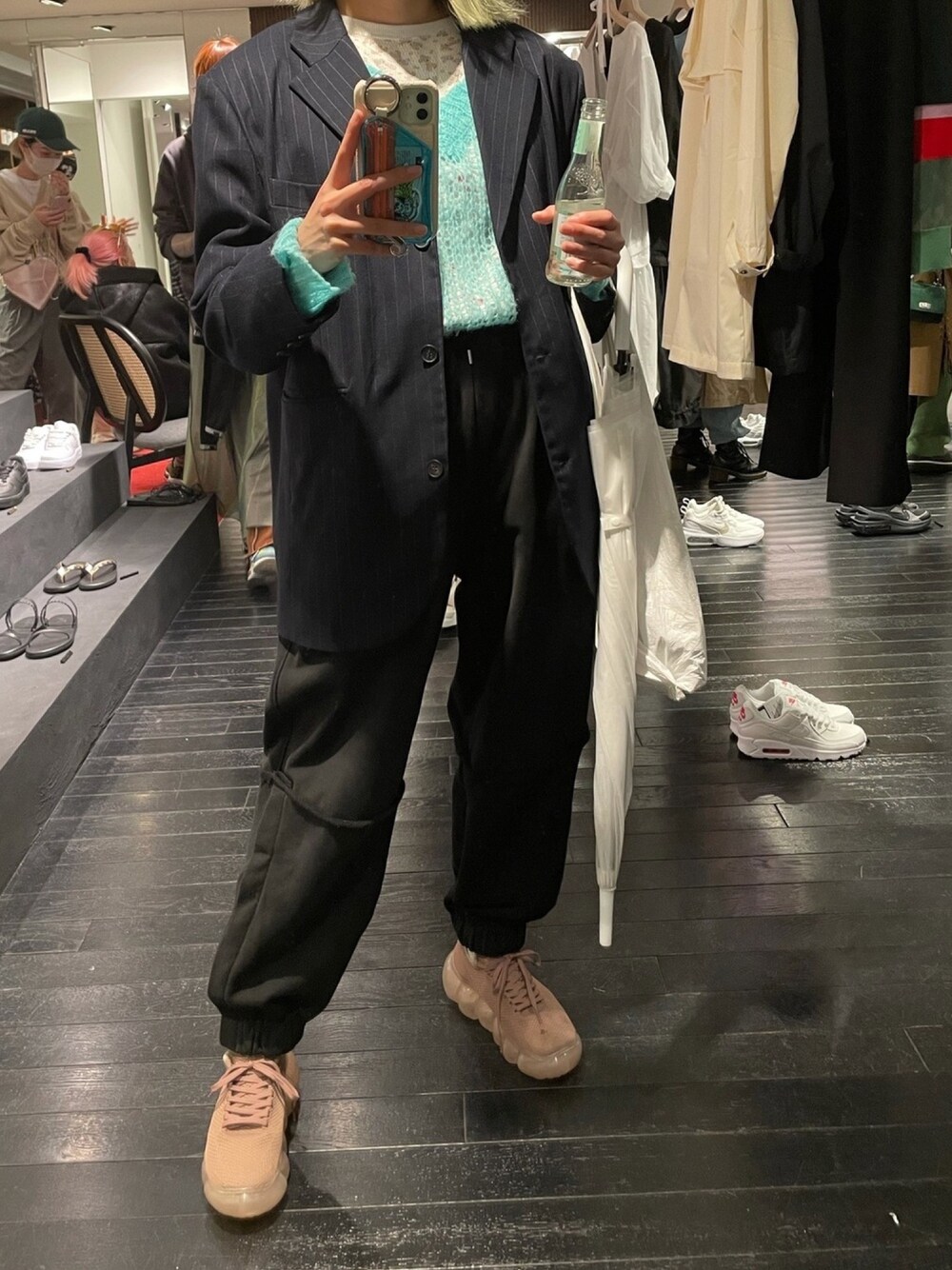 ブラック系のスウェットパンツ、ブラウン系のスニーカー、グリーン系のニット/セーターを着用したレディースの春コーディネートの1枚目の写真