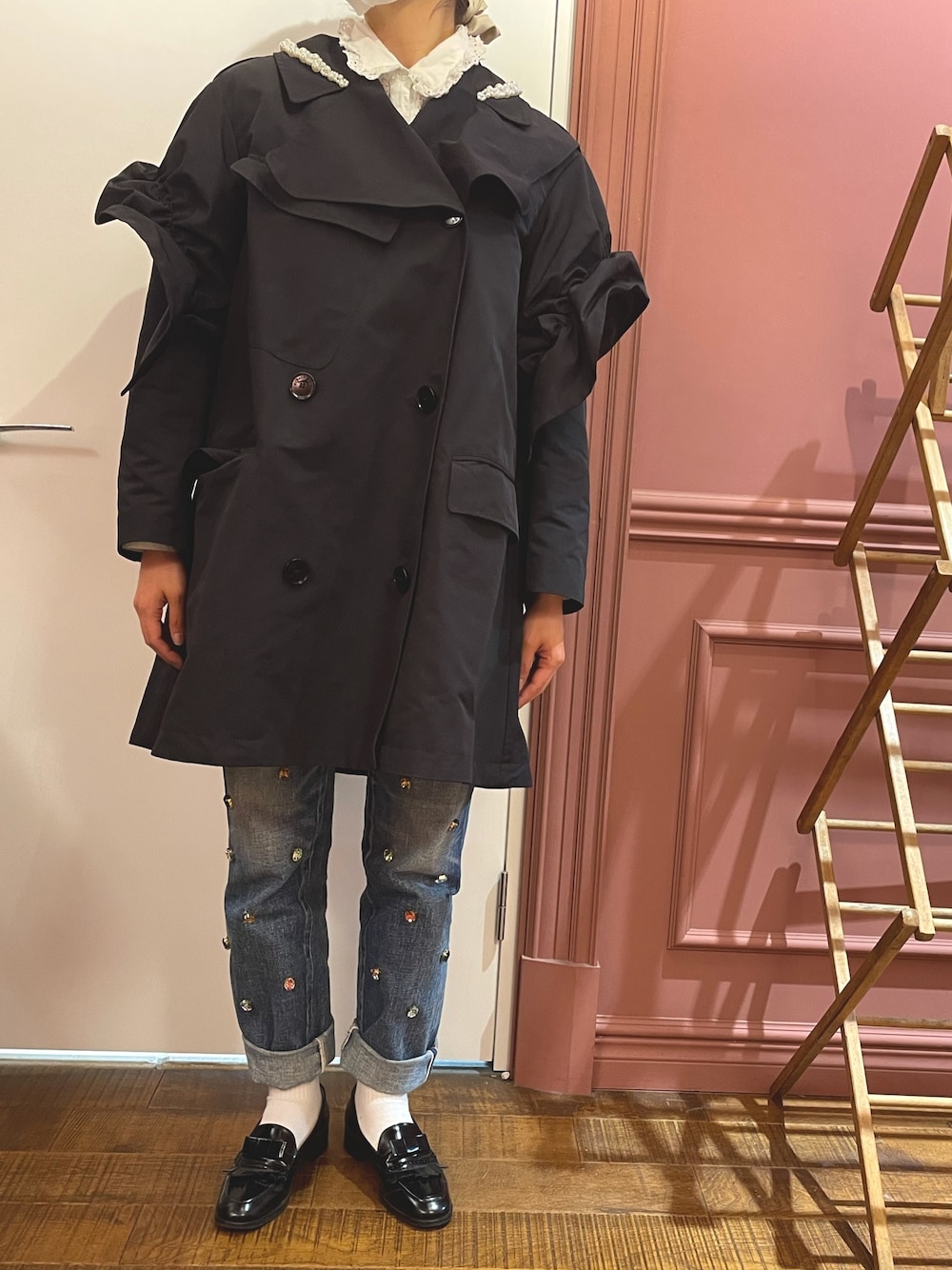 ブラック系のトレンチコート、ブルー系のデニムパンツ、ブラック系のローファーを着用したレディースの春コーディネートの1枚目の写真