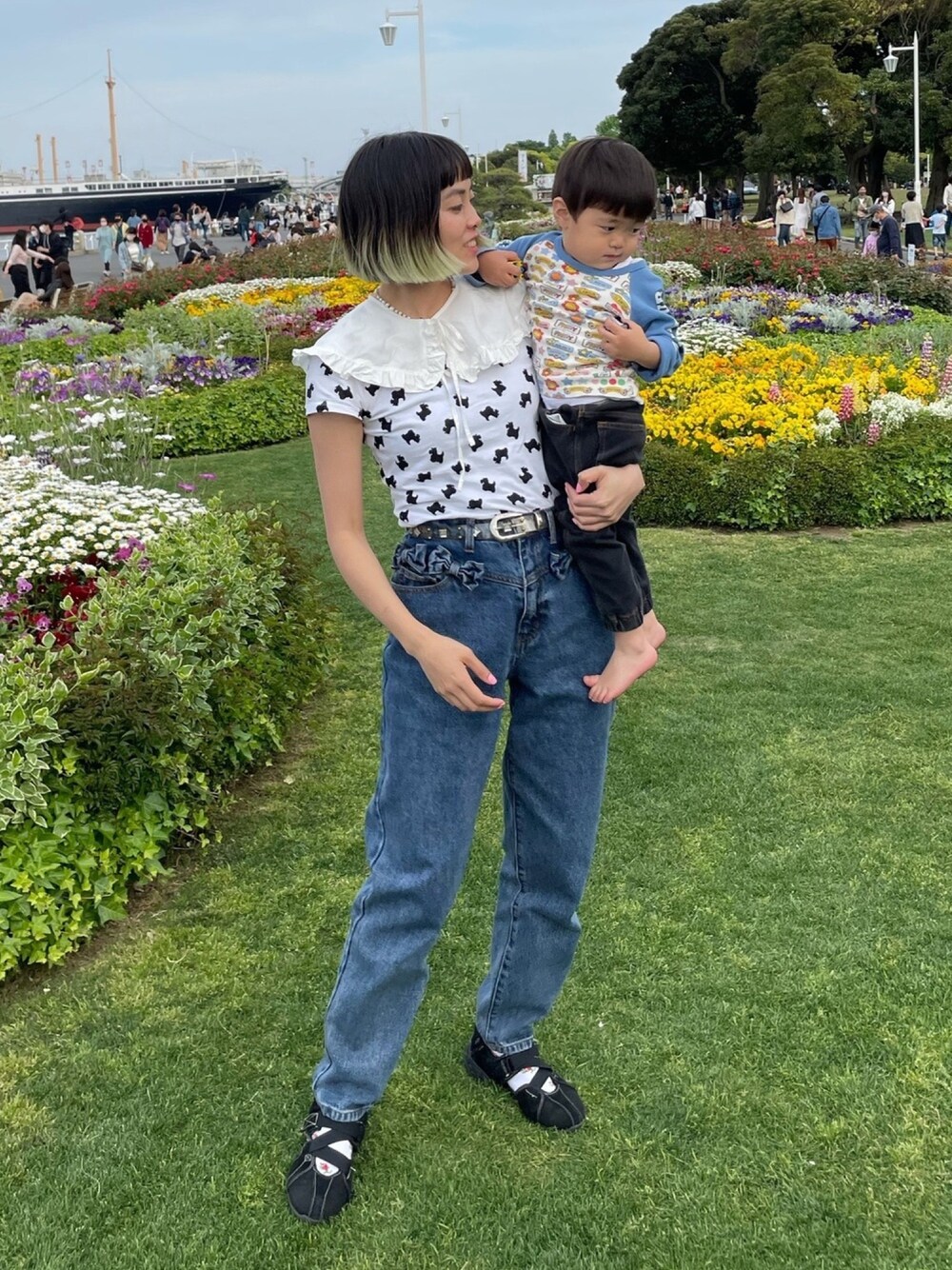 ブルー系のデニムパンツ、ホワイト系のTシャツ/カットソー、ブラック系のスニーカーを着用したレディースの春コーディネートの1枚目の写真