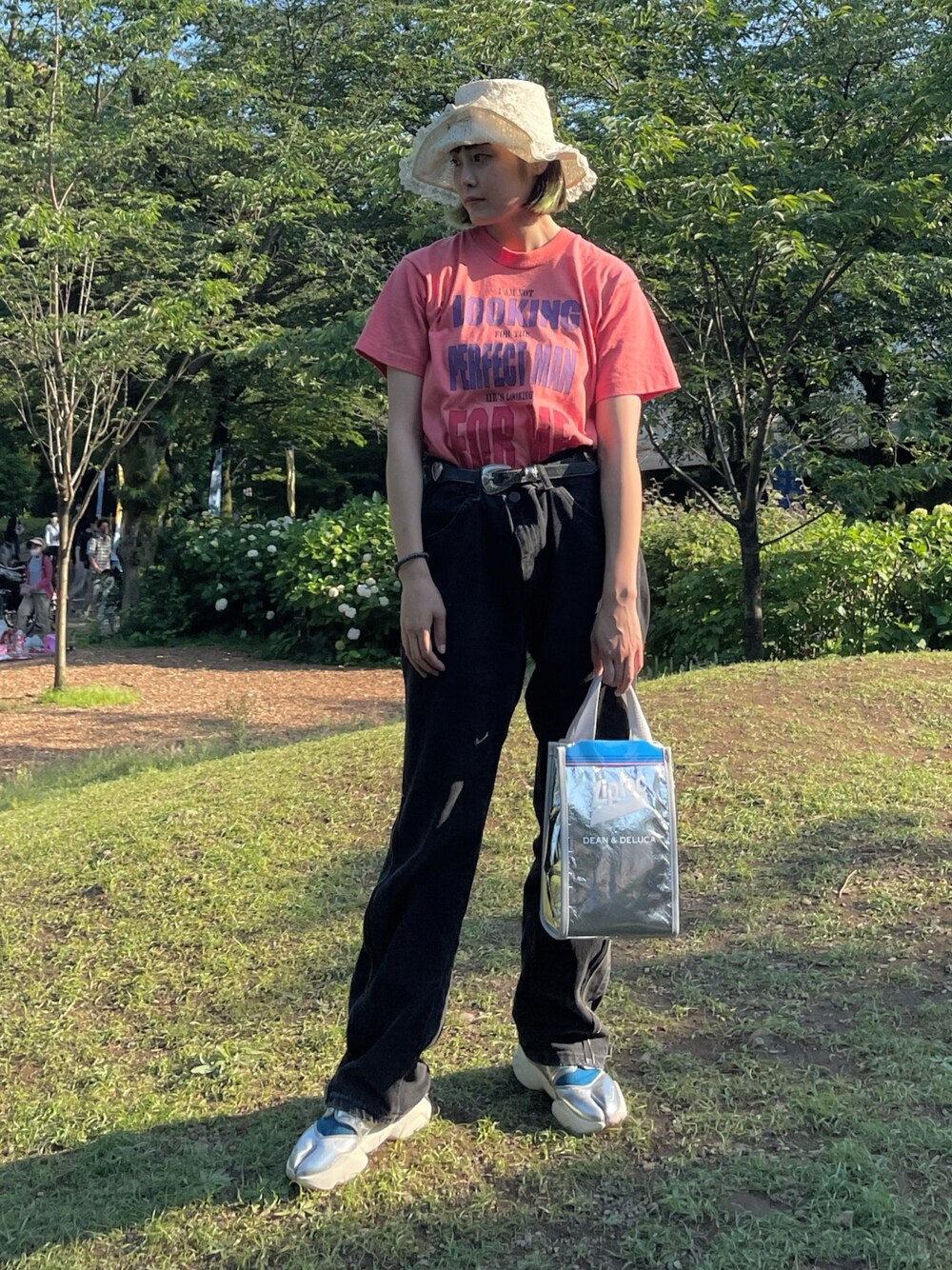 レッド系のTシャツ/カットソー、シルバー系のトートバッグ、ブラック系のデニムパンツを着用したレディースの春コーディネートの1枚目の写真