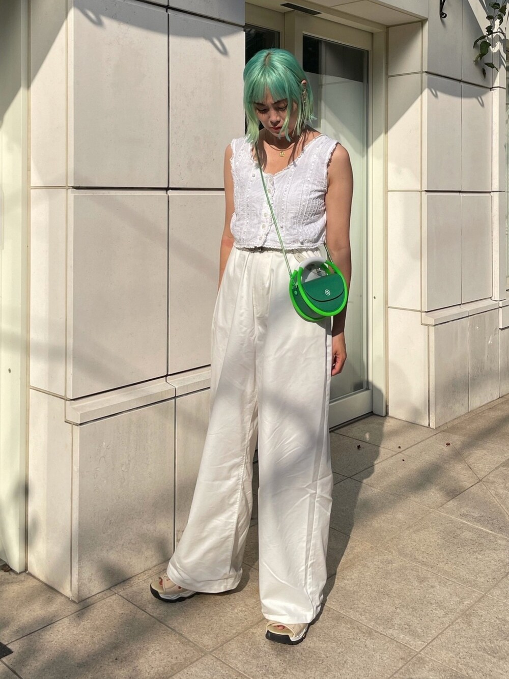 ホワイト系のシャツ/ブラウス、ホワイト系のパンツ、グリーン系のバッグを着用したレディースの夏コーディネートの1枚目の写真