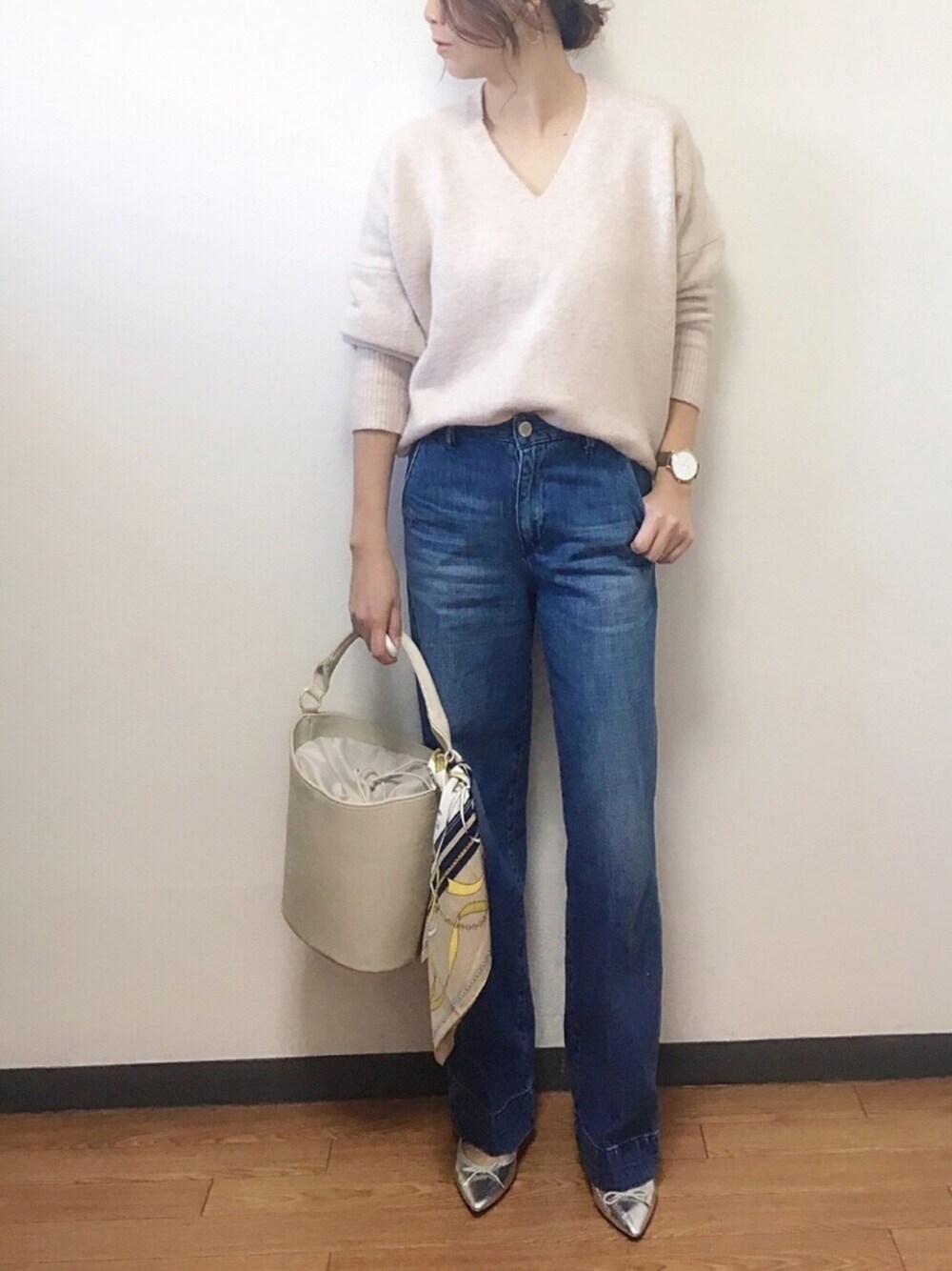 ピンク系のニット/セーター、ブルー系のデニムパンツ、グレー系のショルダーバッグを着用したレディースの冬コーディネートの1枚目の写真