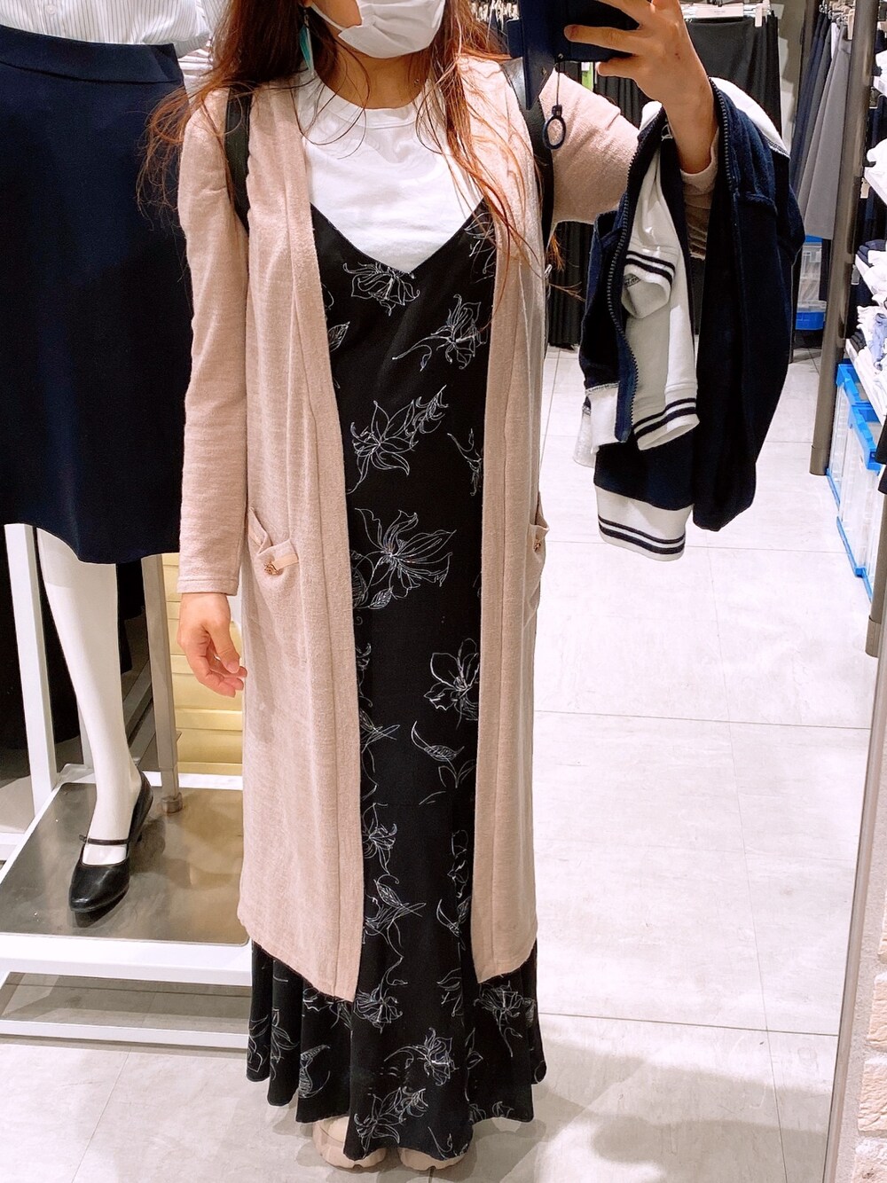 ブラック系のワンピース、ベージュ系のカーディガン/ボレロ、ベージュ系のスニーカーを着用したレディースの春コーディネートの1枚目の写真