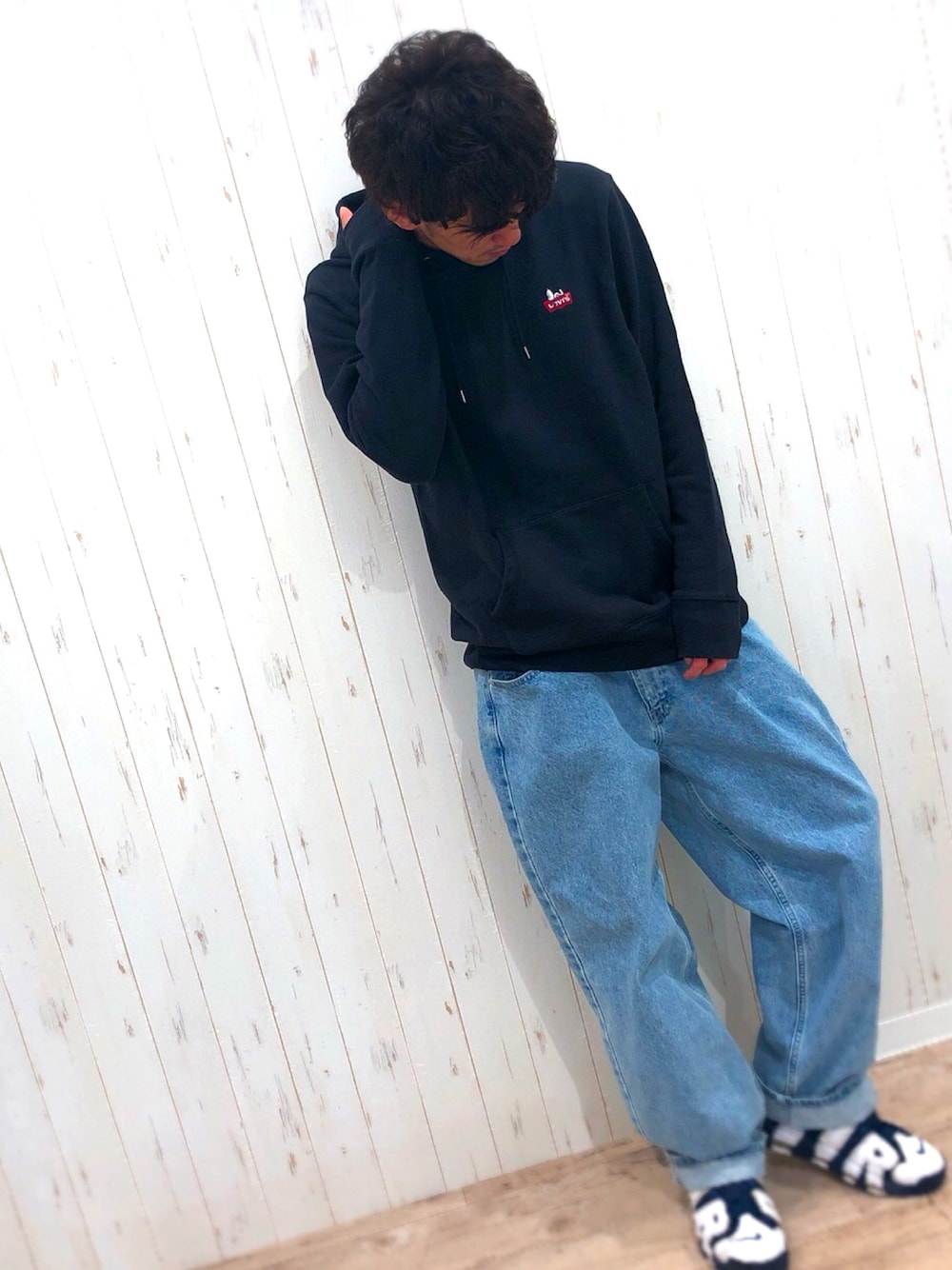 ブラック系のパーカー、ブルー系のデニムパンツ、ブルー系のスニーカーを着用したメンズの冬コーディネートの1枚目の写真