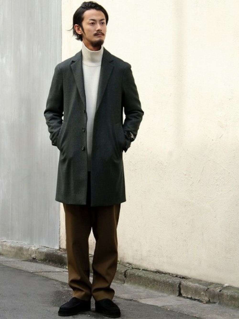 グリーン系のチェスターコートを着用したメンズの秋コーディネートの1枚目の写真