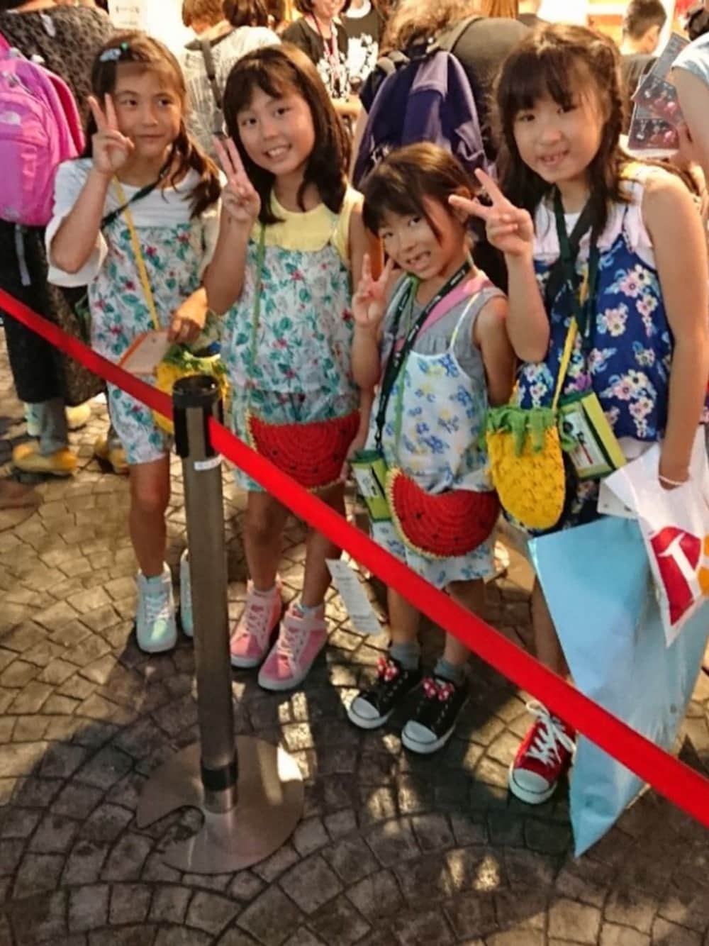 グリーン系のスニーカー、ブルー系のつなぎ/オールインワン、イエロー系のショルダーバッグを着用したキッズの夏コーディネートの1枚目の写真