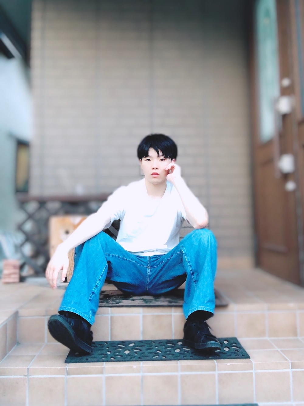 ブラック系のスニーカー、ブルー系のデニムパンツ、ホワイト系のTシャツ/カットソーを着用したメンズの夏コーディネートの1枚目の写真