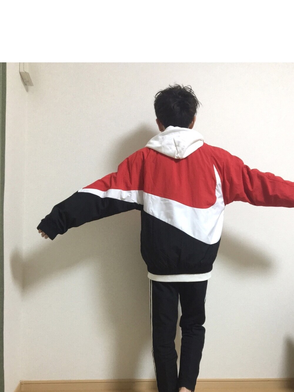 レッド系のブルゾン、ブラック系のスウェットパンツを着用したメンズの冬コーディネートの1枚目の写真