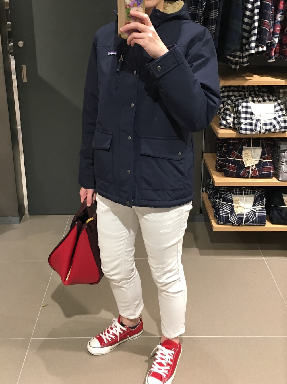 ブルー系のマウンテンパーカー、ホワイト系のデニムパンツ、レッド系のスニーカーを着用したレディースの冬コーディネートの1枚目の写真