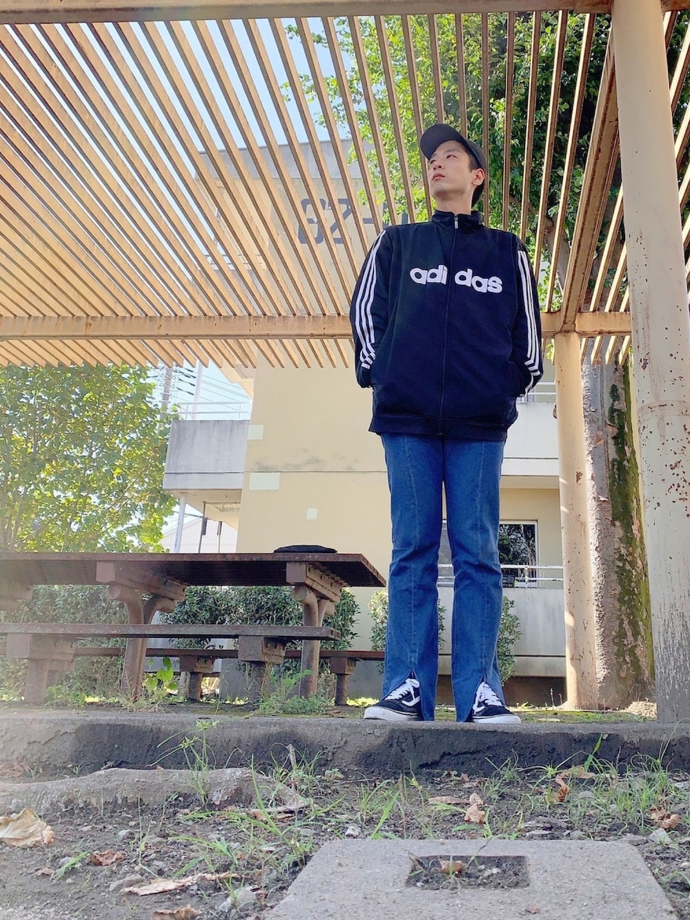 ブラック系のジャージ、ブルー系のデニムパンツ、ブラック系のスニーカーを着用したメンズの秋コーディネートの1枚目の写真