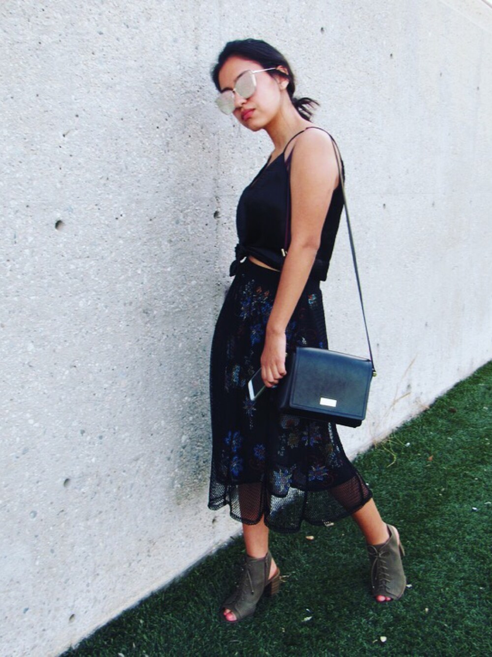 ブラック系のショルダーバッグ、ブラック系のキャミソール、ブラック系のスカートを着用したレディースの春コーディネートの1枚目の写真