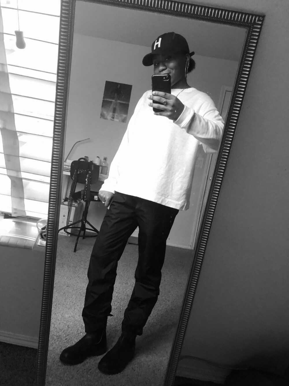 ブラック系のスウェットパンツ、ブラック系のブーツ、ブラック系のキャップを着用したレディースの冬コーディネートの1枚目の写真