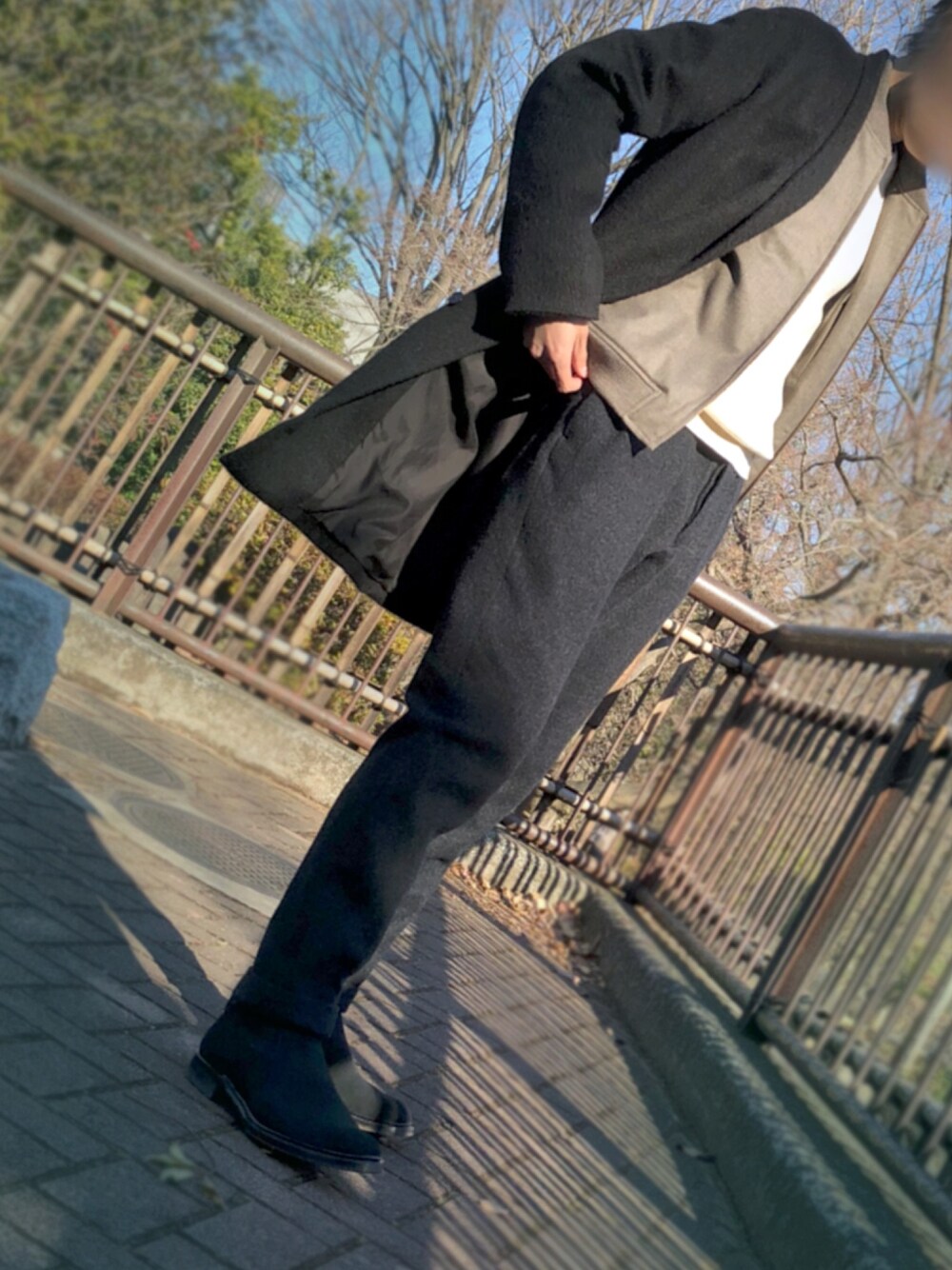 ブラック系のチェスターコート、ベージュ系のブルゾン、グレー系のスラックスを着用したメンズの冬コーディネートの1枚目の写真