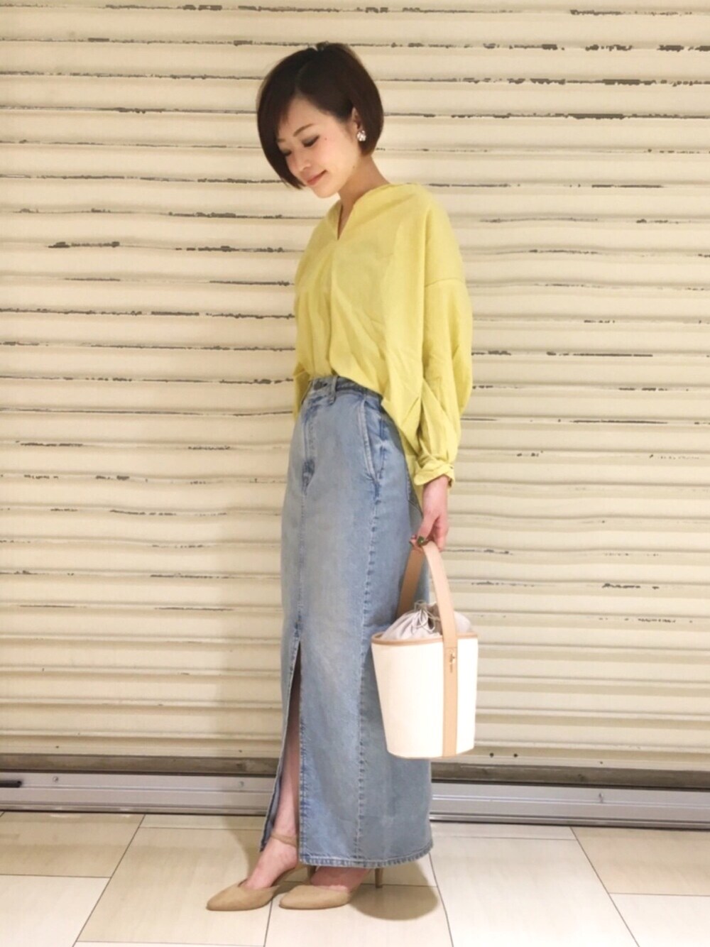 イエロー系のシャツ/ブラウス、ホワイト系のショルダーバッグ、ベージュ系のパンプスを着用したレディースの冬コーディネートの1枚目の写真