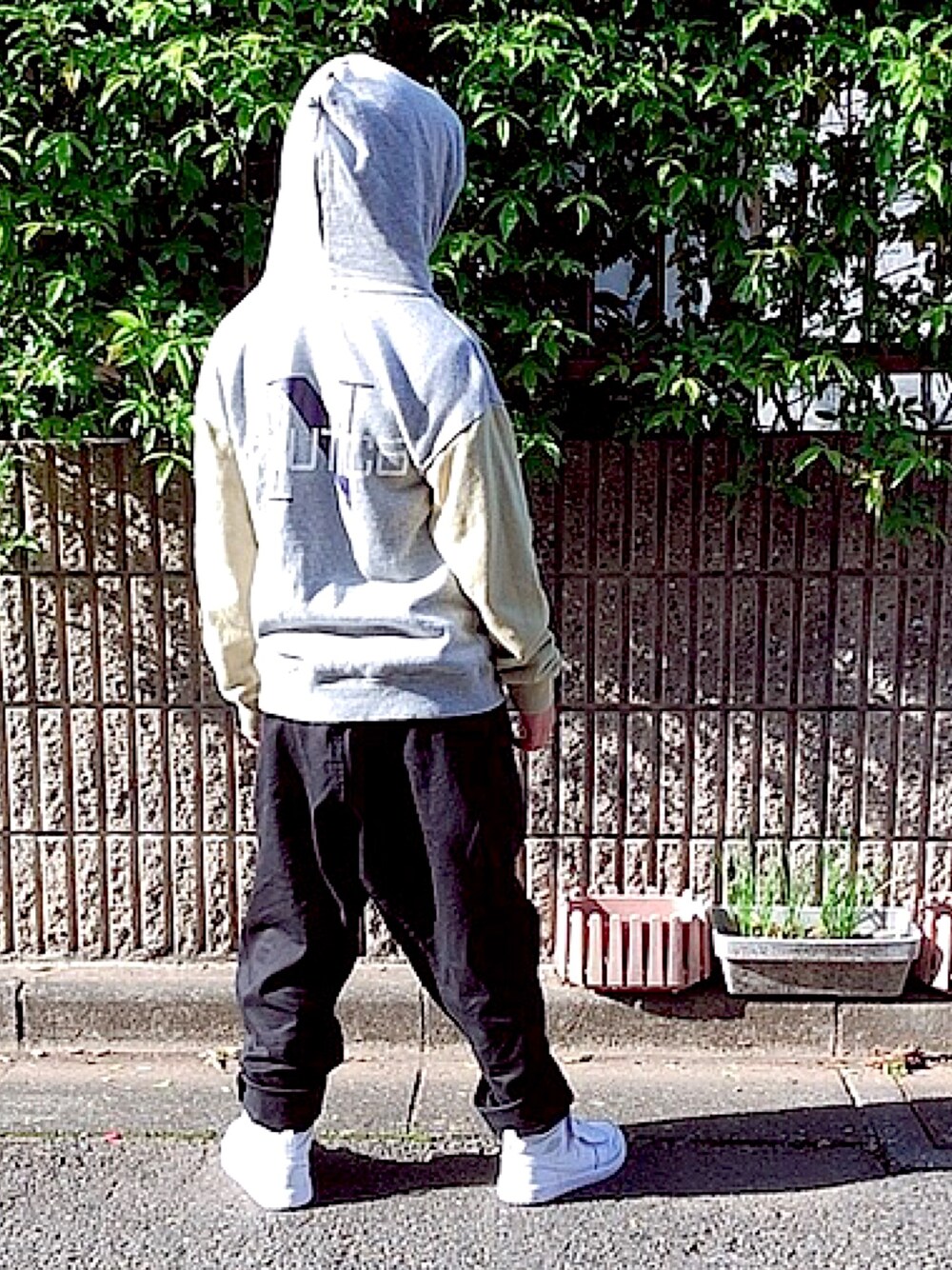 グレー系のパーカー、ブラック系のその他パンツ、ホワイト系のスニーカーを着用したレディースの春コーディネートの1枚目の写真