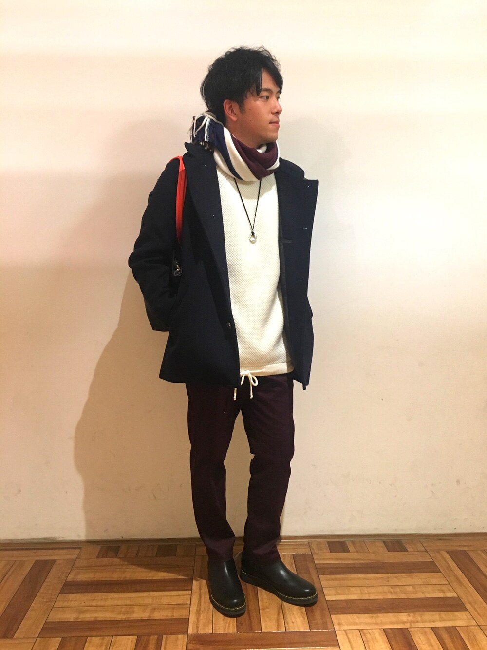 ブラック系のブーツ、レッド系のその他パンツ、ホワイト系のニット/セーターを着用したメンズの秋コーディネートの1枚目の写真
