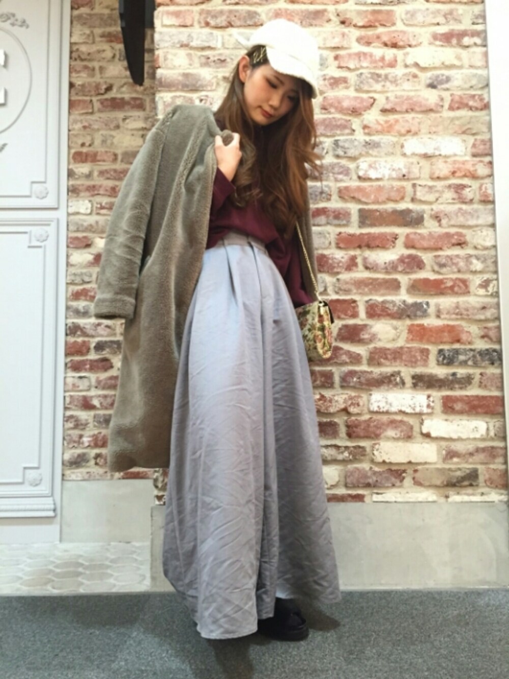 ブラウン系のその他アウター、ホワイト系のショルダーバッグ、ブラック系のサンダルを着用したレディースの冬コーディネートの1枚目の写真