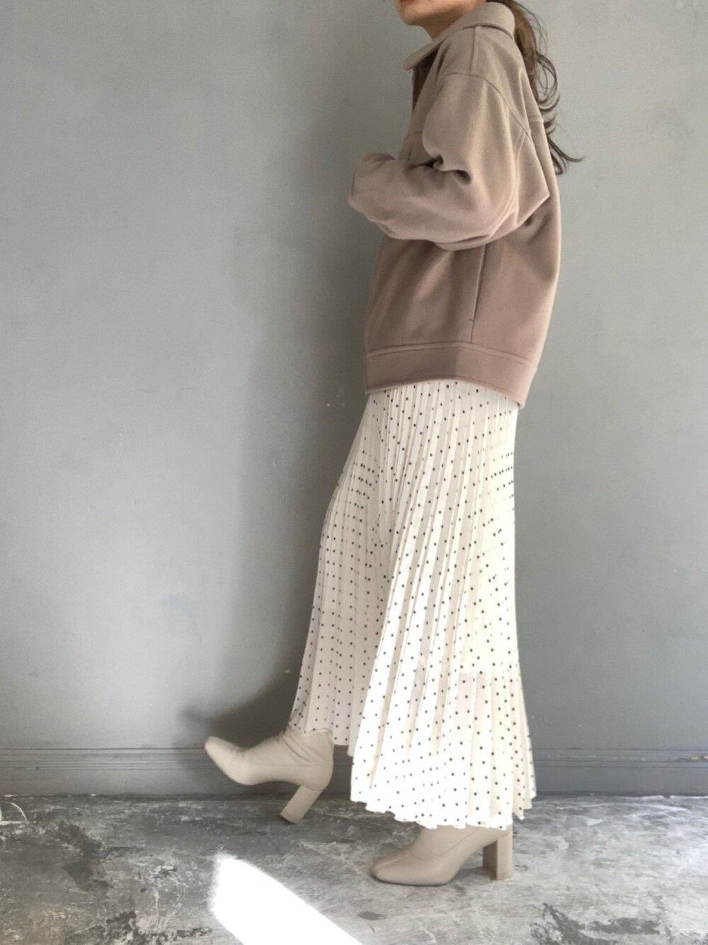 ホワイト系のブルゾン、その他のスカート、ホワイト系のブーツを着用したレディースの冬コーディネートの1枚目の写真