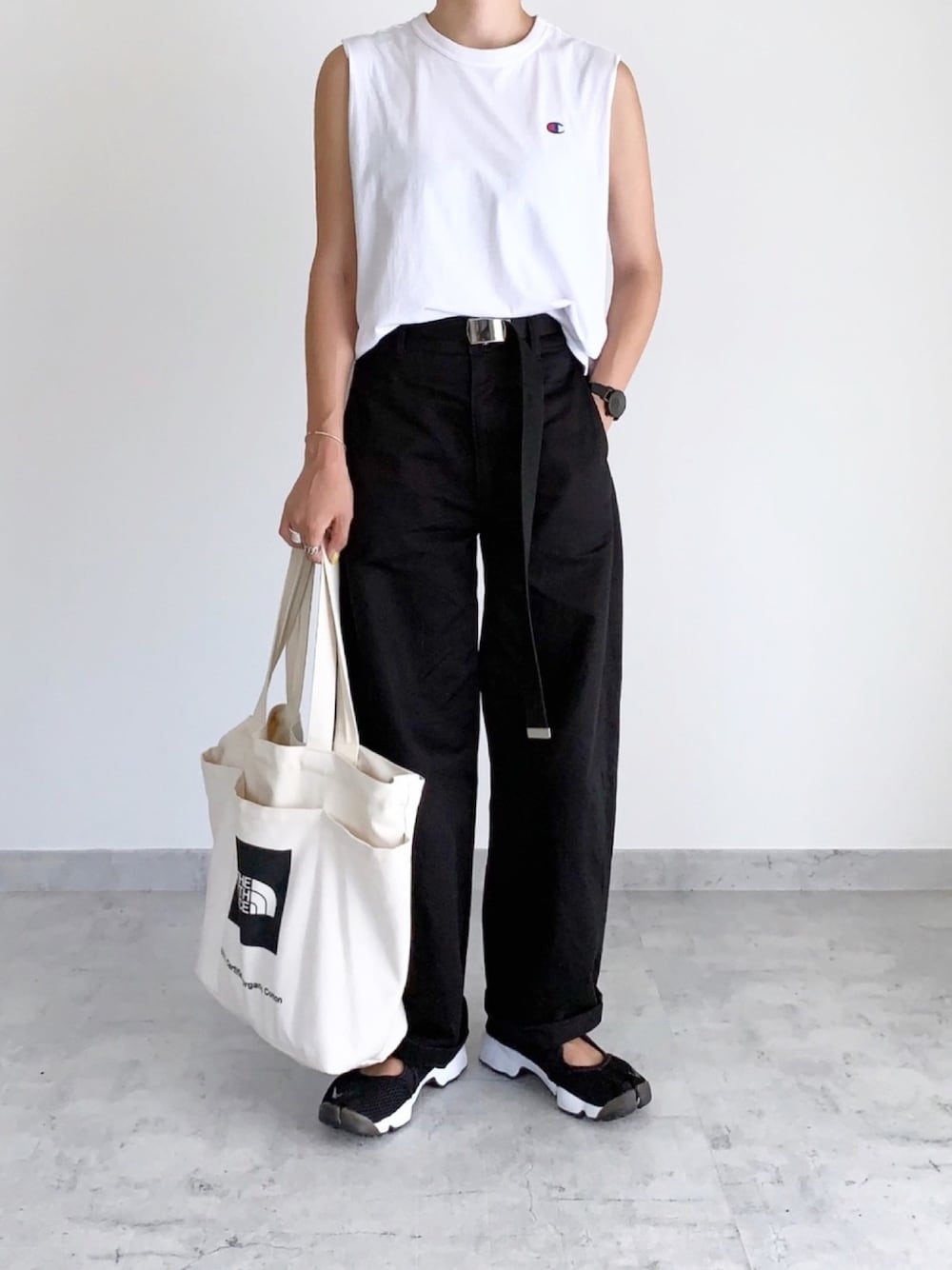 ホワイト系のタンクトップ、ホワイト系のトートバッグ、ブラック系のその他パンツを着用したレディースの夏コーディネートの1枚目の写真