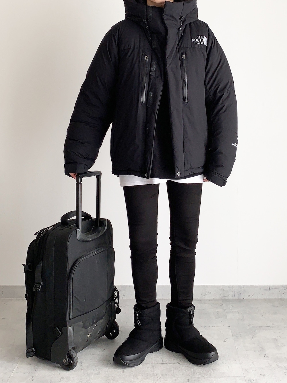 ブラック系のダウンジャケット/コート、ブラック系のブーツ、ブラック系のデニムパンツを着用したレディースの冬コーディネートの1枚目の写真