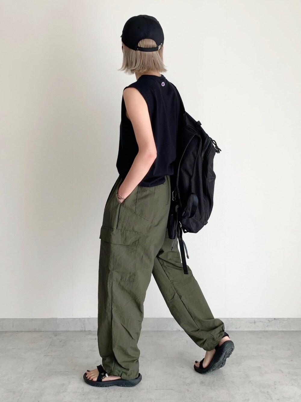 ブラック系のサンダル、グリーン系のその他パンツ、ブラック系のバックパック/リュックを着用したレディースの秋コーディネートの1枚目の写真