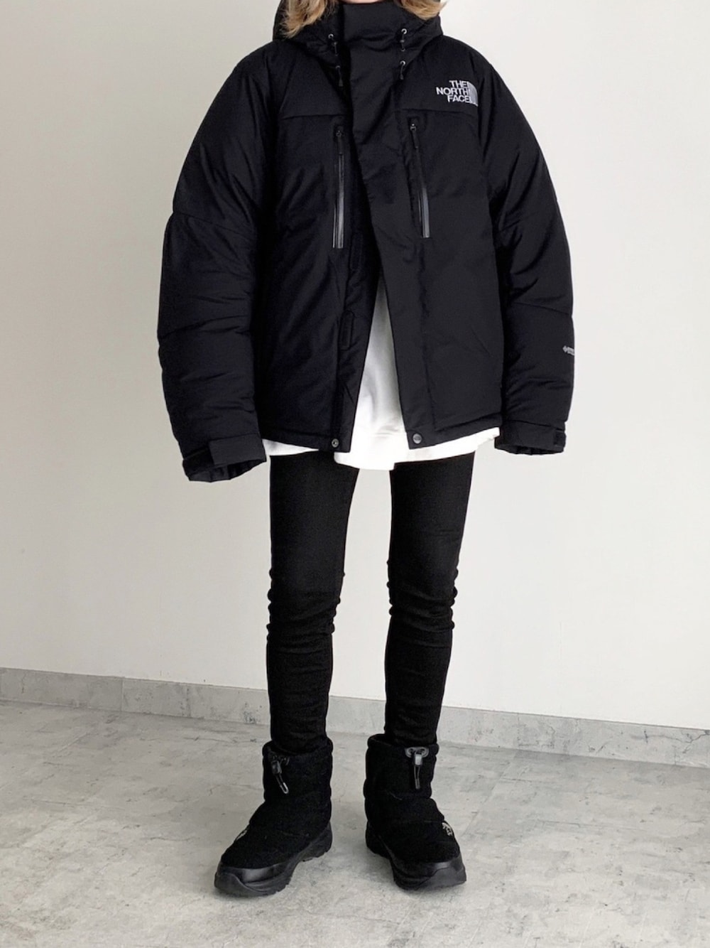 ブラック系のダウンジャケット/コート、ブラック系のパンツ、ブラック系のブーツを着用したレディースの冬コーディネートの1枚目の写真