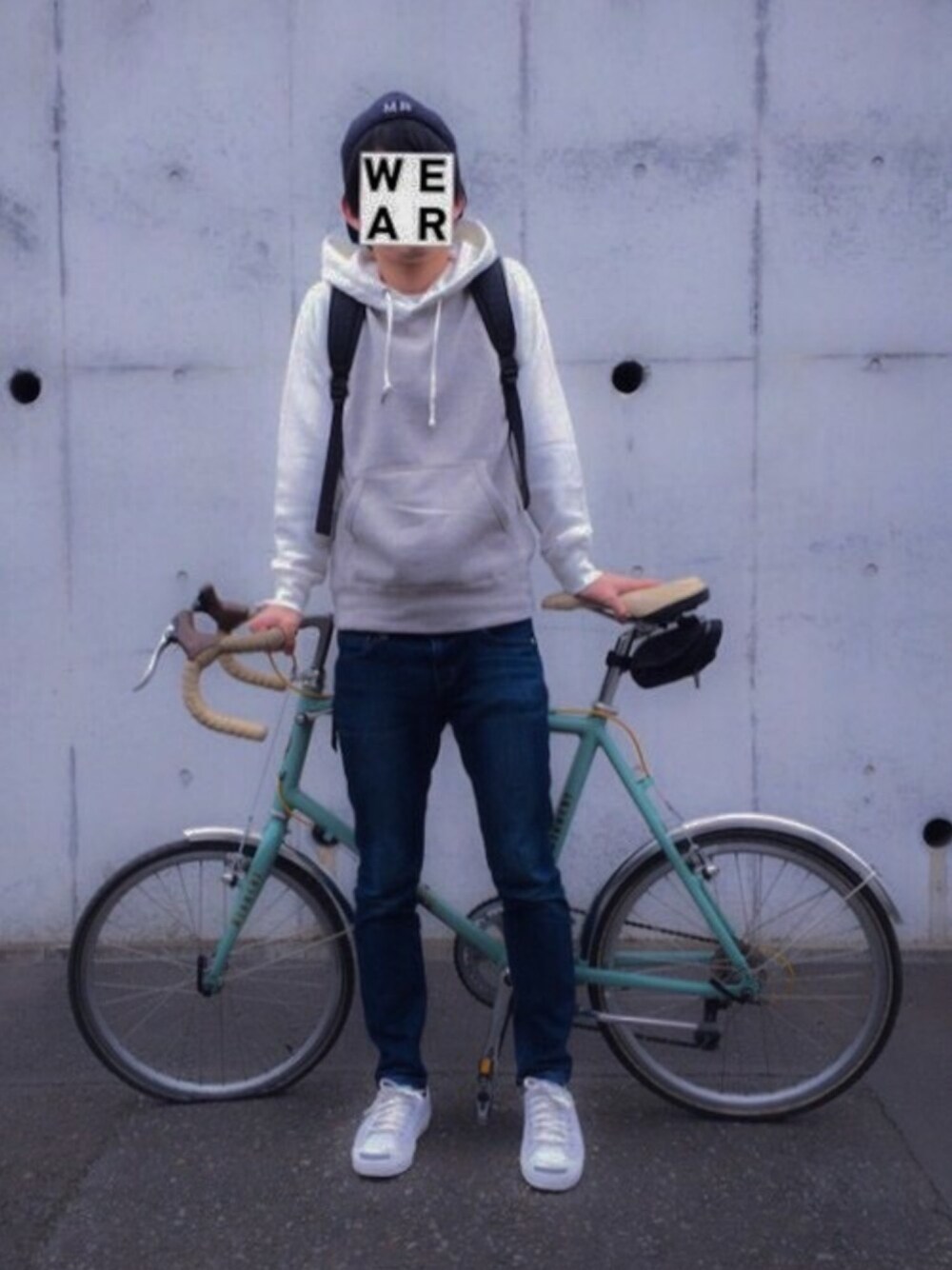 ブルー系のデニムパンツ、ホワイト系のパーカー、ブラック系のバックパック/リュックを着用したメンズの春コーディネートの1枚目の写真